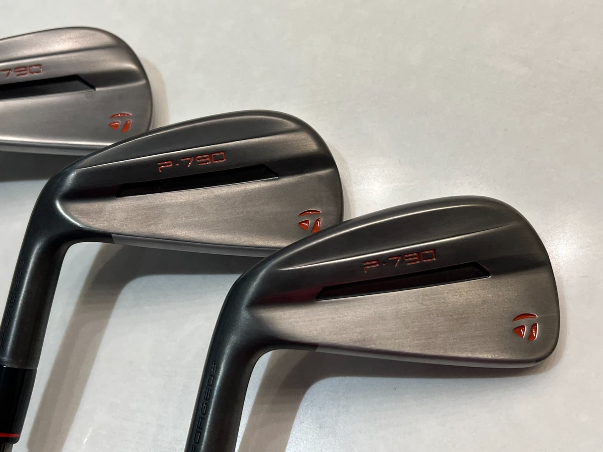 Custom TaylorMade P-790 iron heads, smoked gunmetal finish, built by T's Golf Lab